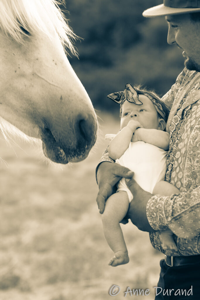 Bébé dans les bras avec nez d'un cheval